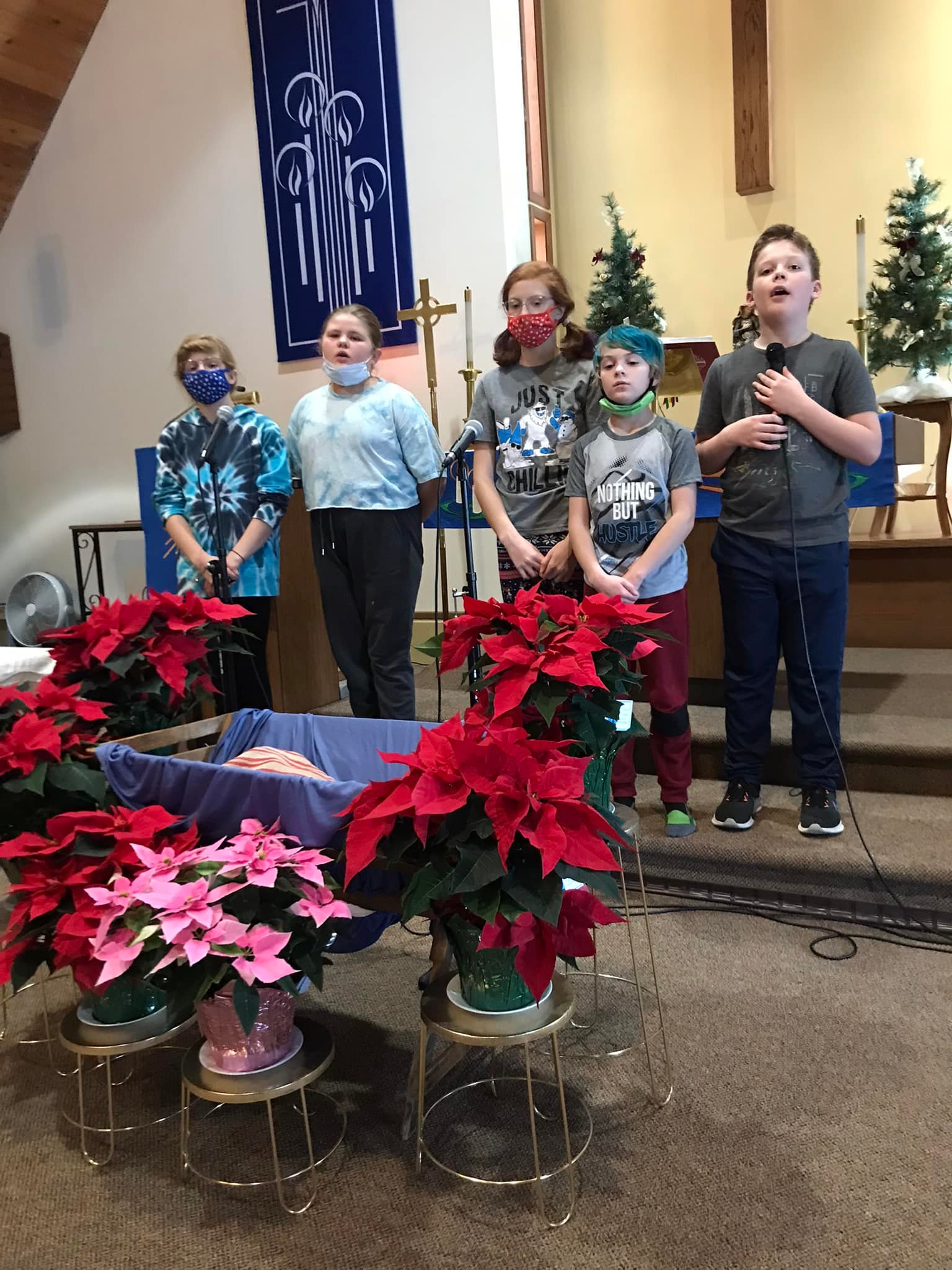 Children's Christmas program choir with manger display.