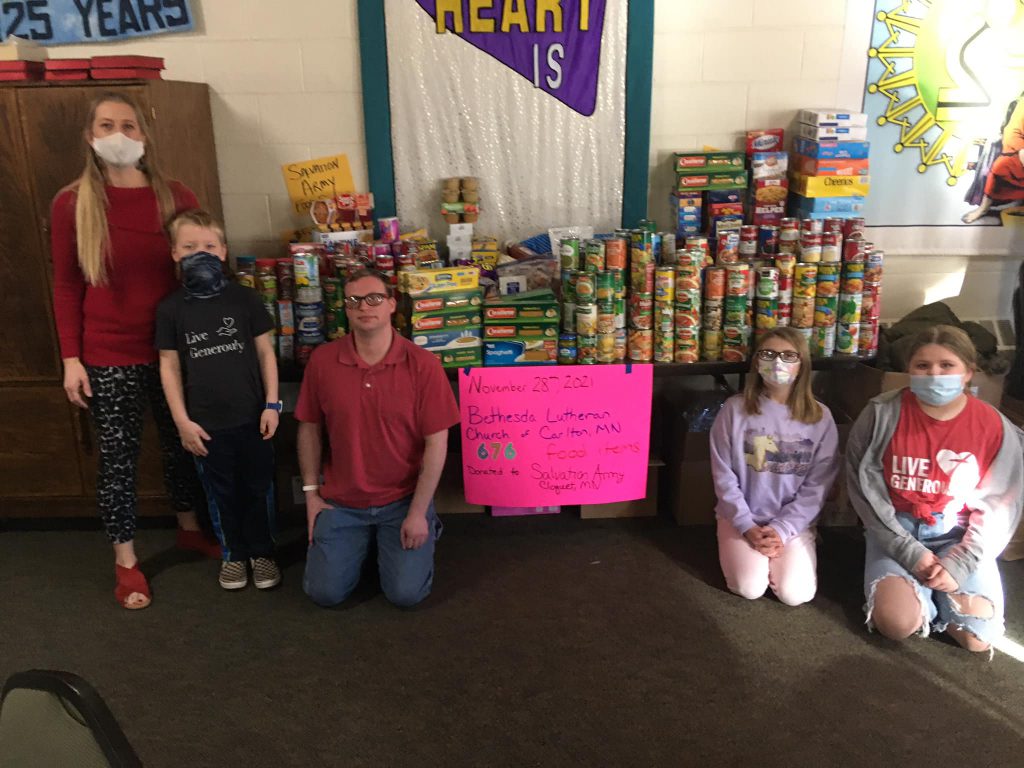 Young volunteers next to the Salvation Army food collection table.